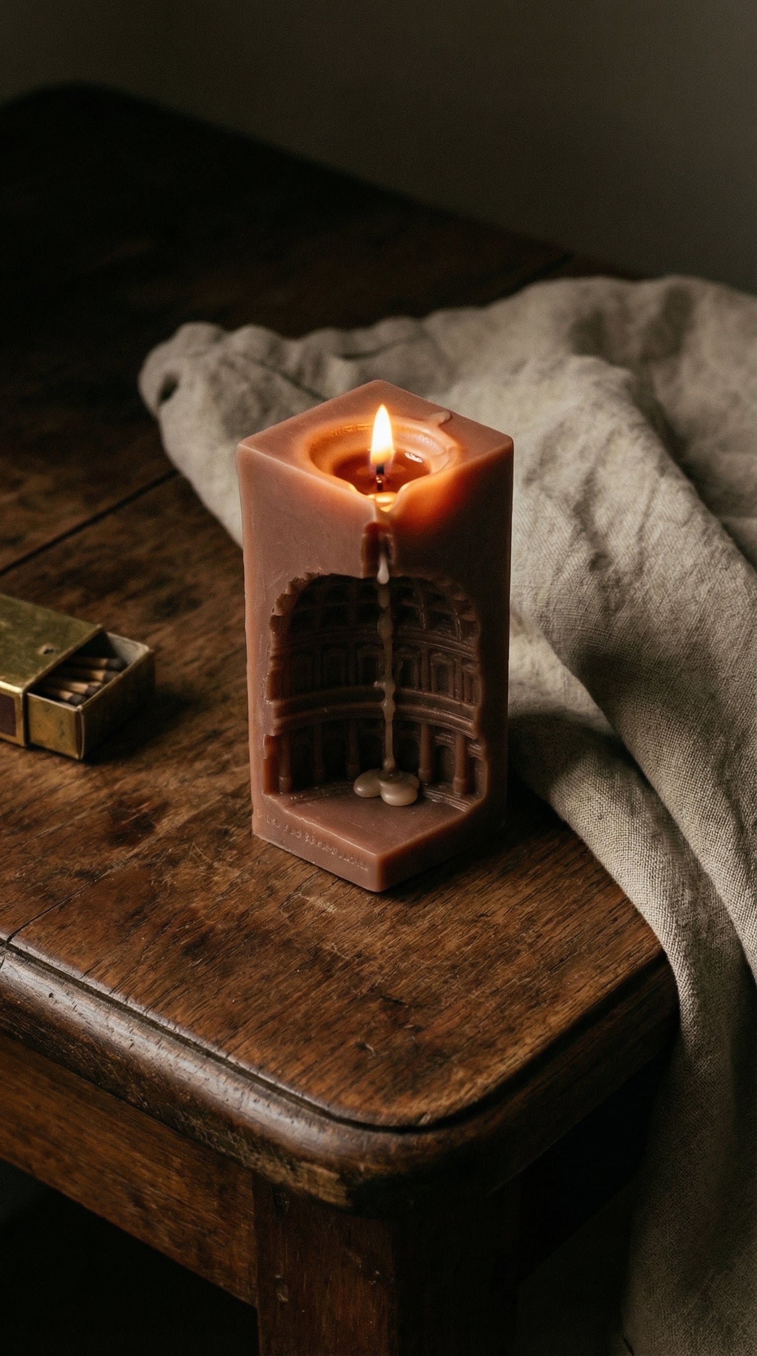 Candle with architectural design on a wooden surface with a soft light