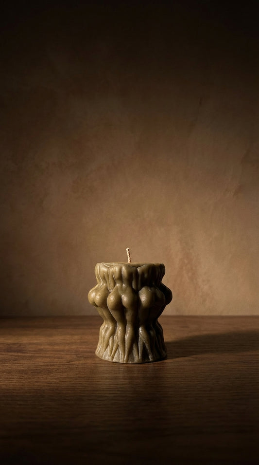Beeswax candle with unique design on a wooden surface and brown background
