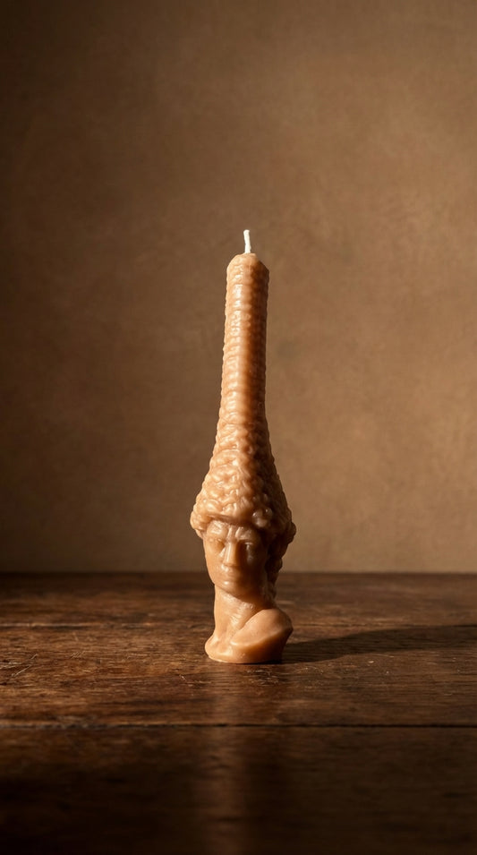 Decorative candle with unique design on a wooden surface and brown background